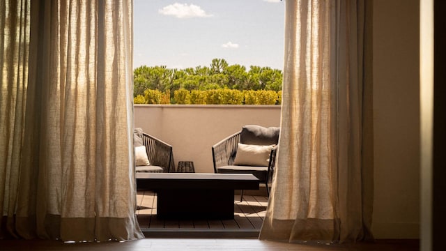 Salida a la terraza con suelo de madera y ventanal vestido con cortinas de lino en tono beige, con dobladillo, suelo de madera 