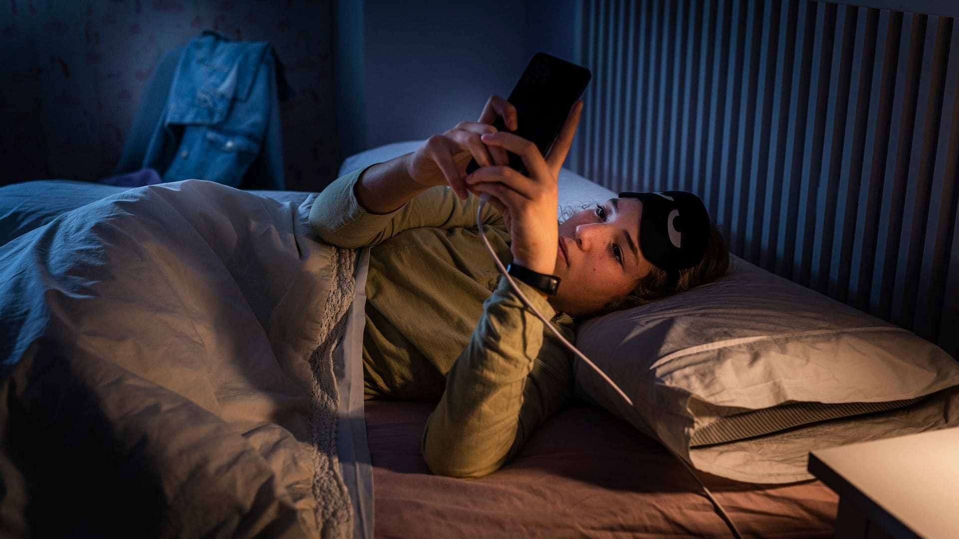 Adolescente que sufre trastornos del sueño usando un smartphone por la noche