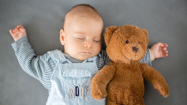 Bebé duerme junto a su osito