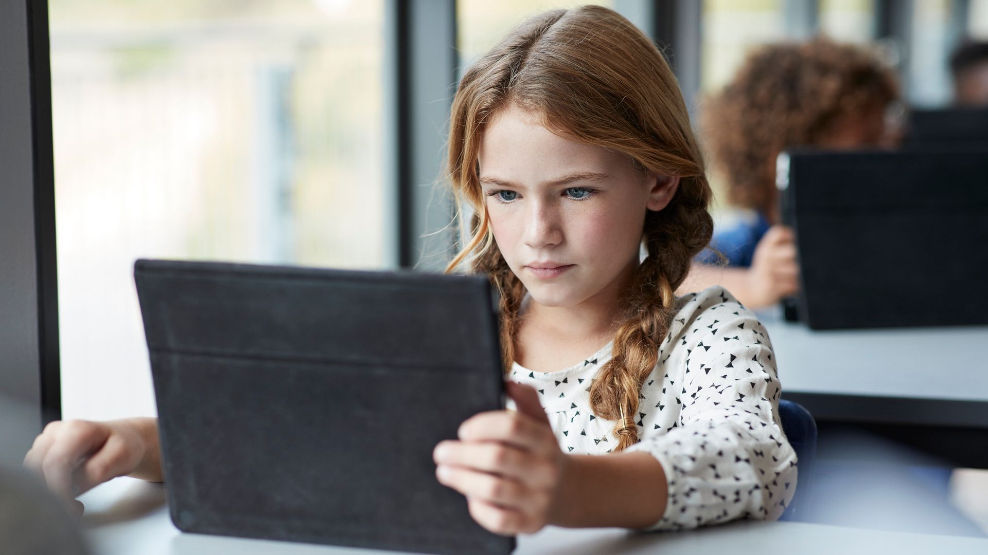 Niña con una tablet en clase