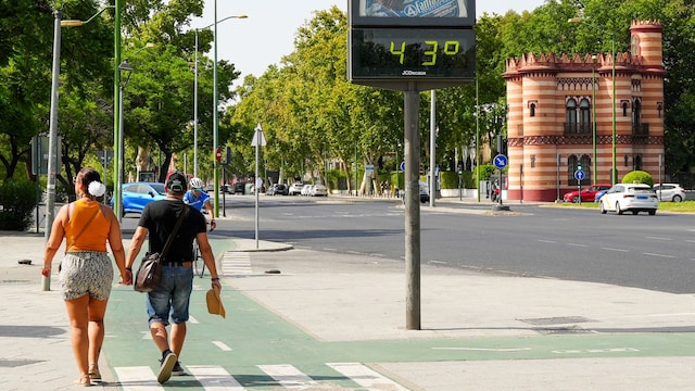 Ola de calor en España: una pareja camina por Sevilla 