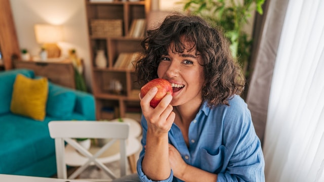 mujer comiendo una manzana roja