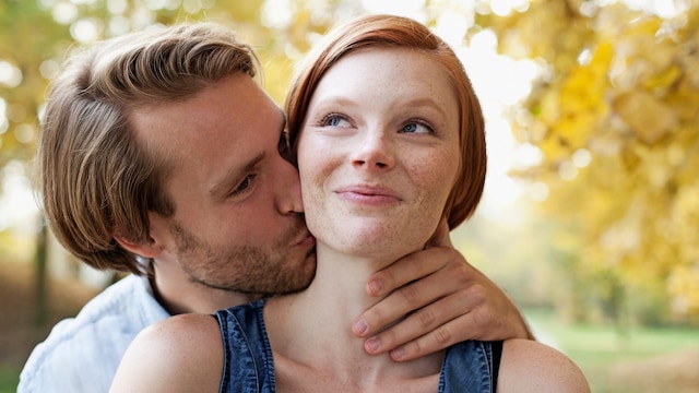 Pareja besándose en el parque demostrando amor