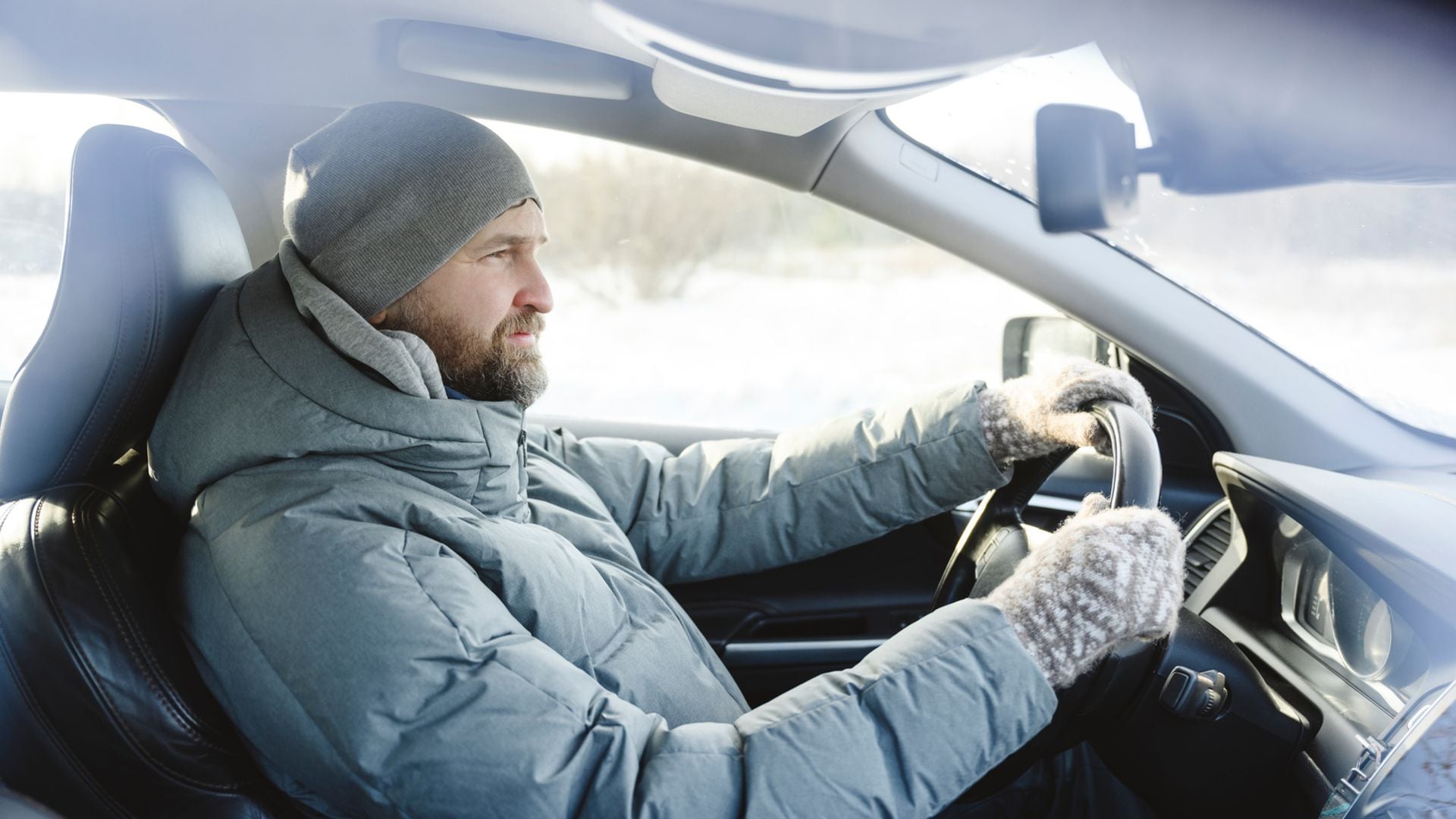 Conduciendo un coche con abrigo y guantes
