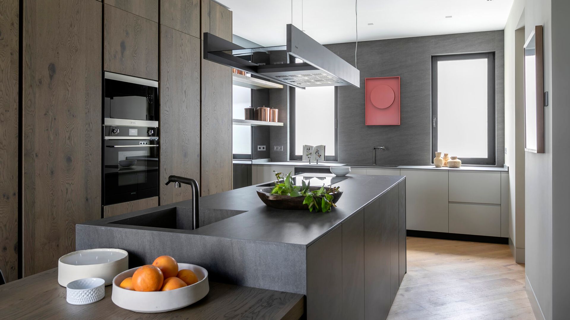 Cocina con isla central, armarios hasta el techo de madera, campana de techo sobre la isla, isla con mesa adosada 