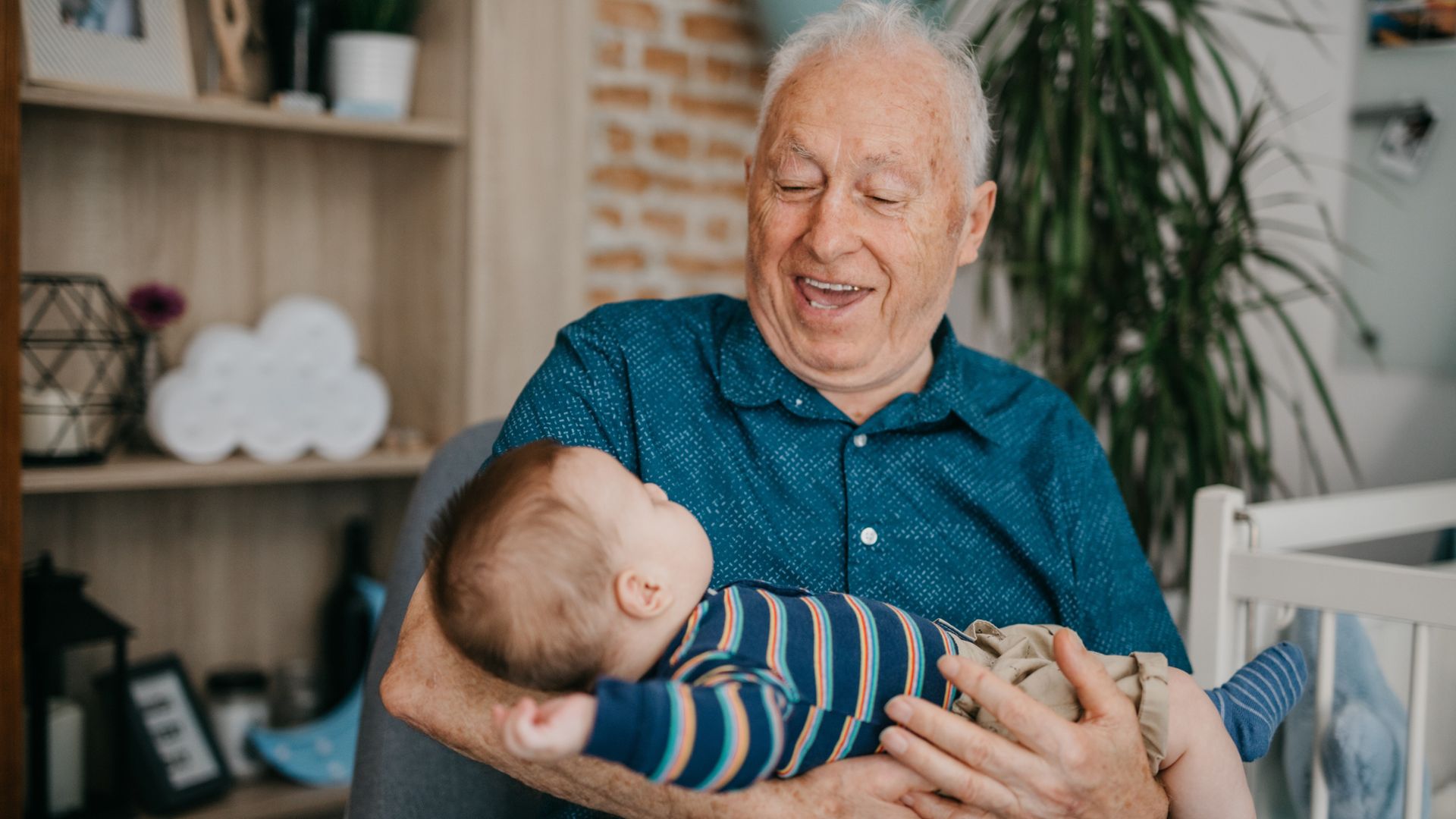 Abuelo feliz con su nieto en brazos