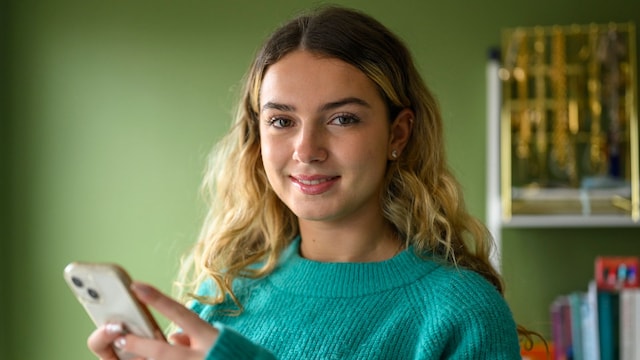 Adolescente feliz con su teléfono móvil