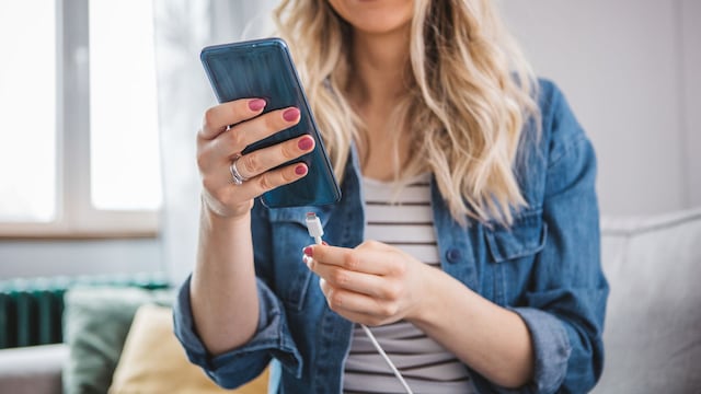 Una mujer cargando su teléfono móvil