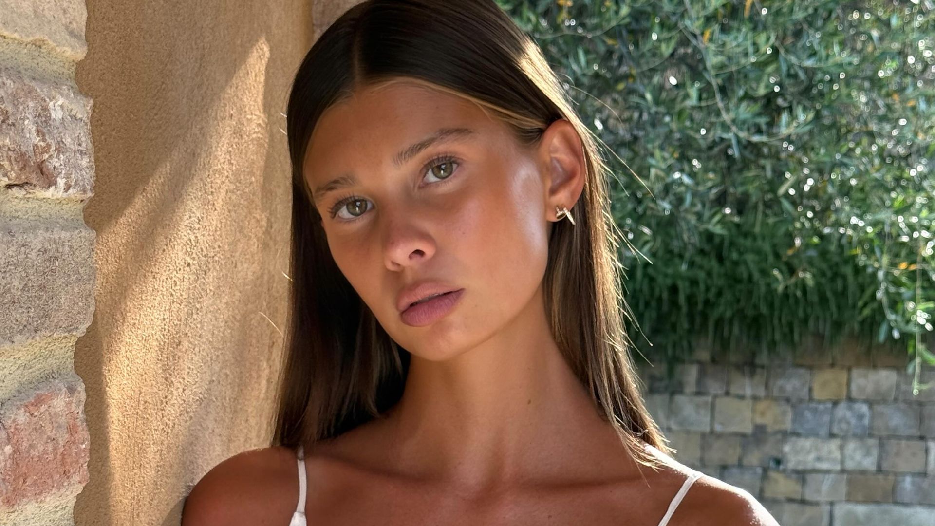 Fiona Briseno con vestido blanco, pelo castaño suelto y maquillaje natural