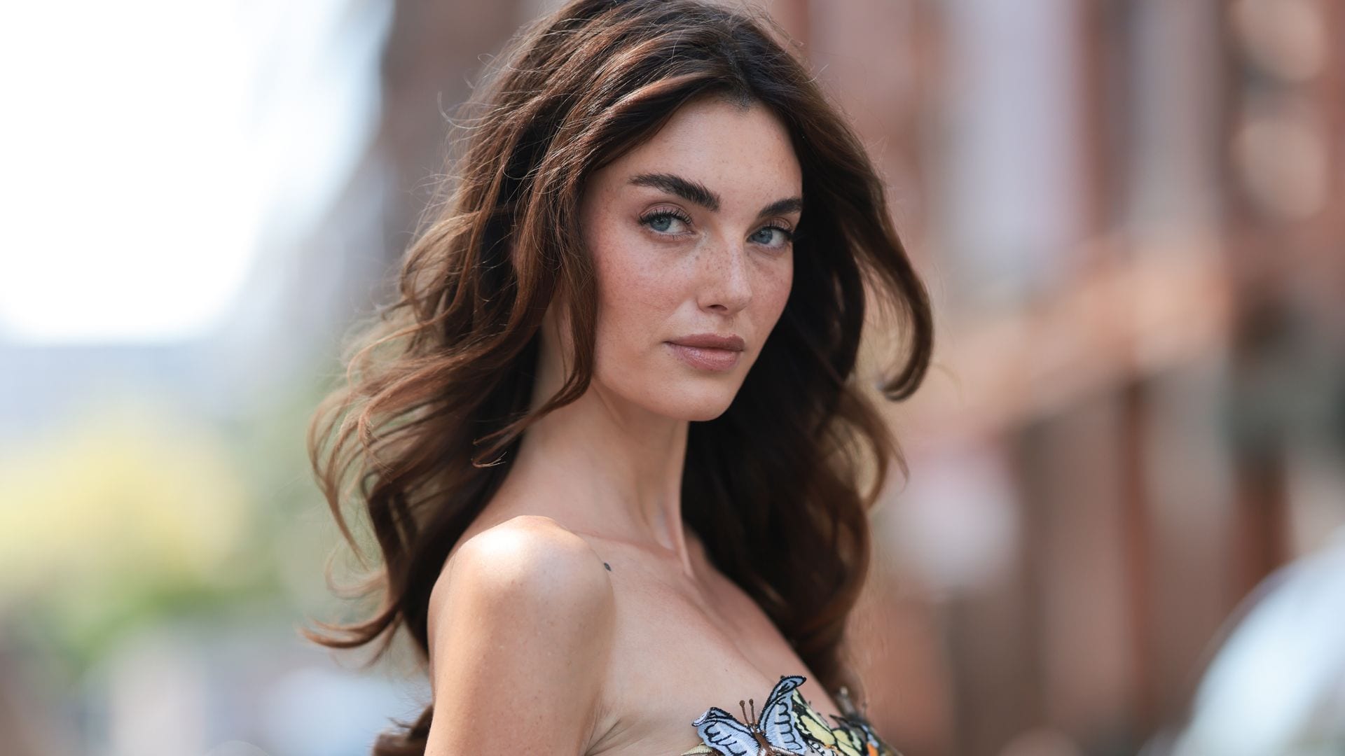 Celine Bethmann con vestido palabra de honor de mariposas y pelo suelto ondulado con volumen
