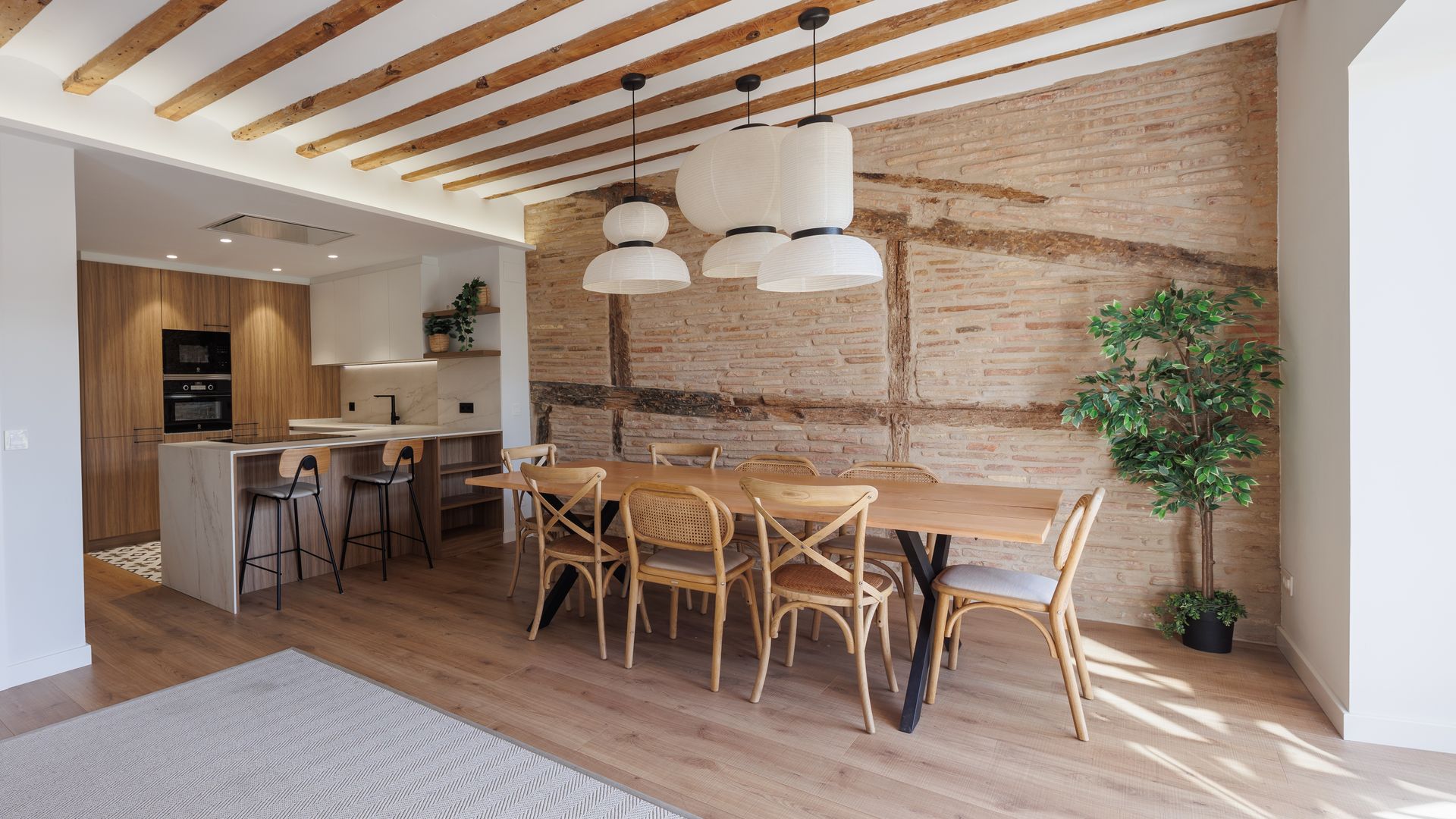 Comedor con pared de ladrillo y techos con vigas