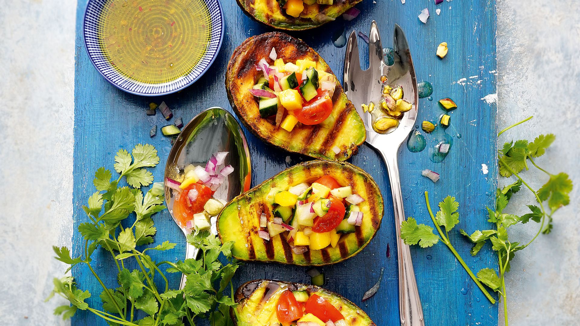 Aguacates a la parrilla con ceviche de verduras, lima y pistachos