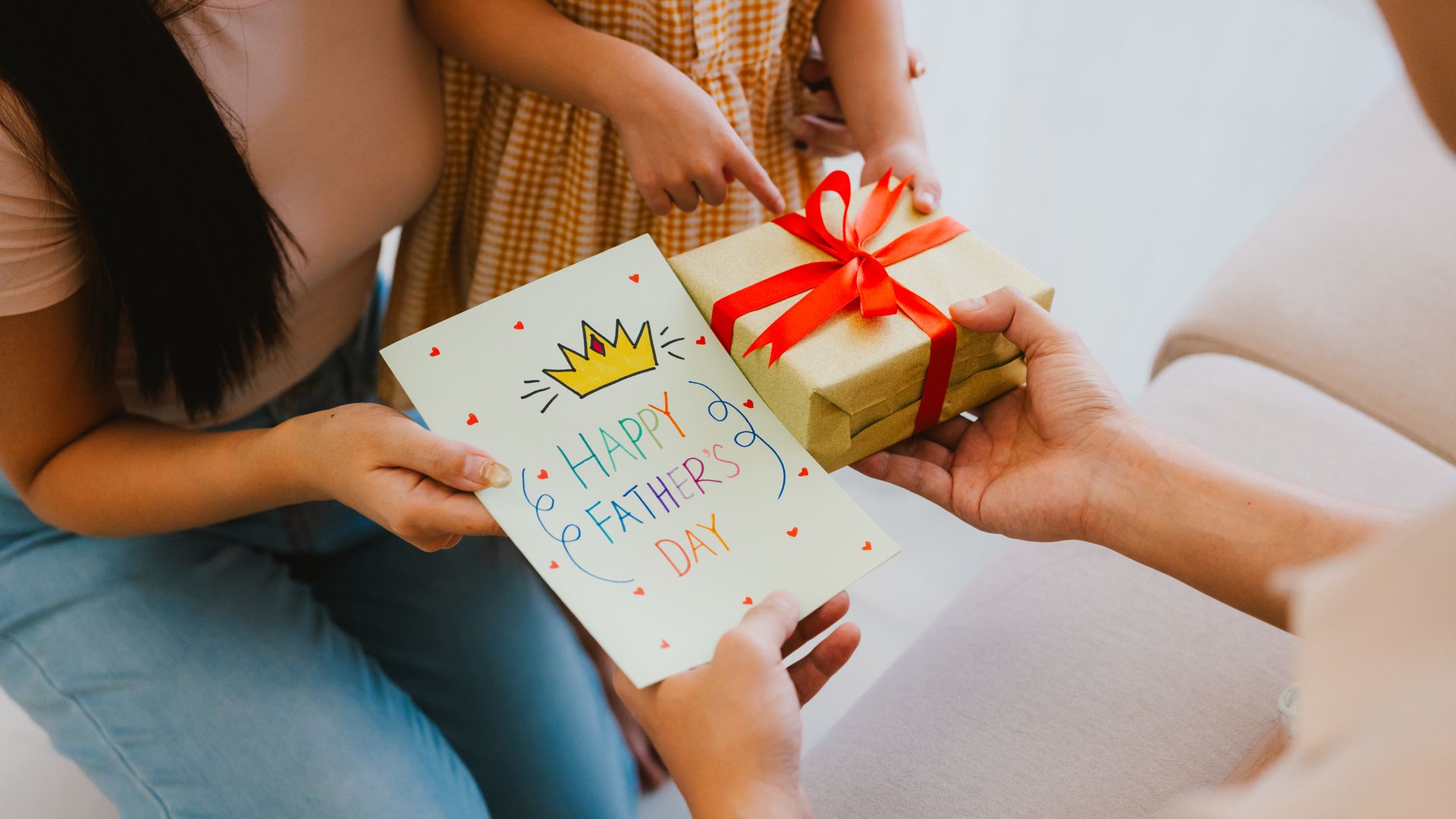Madre e hija dándole regalo y tarjeta del día del padre a su padre