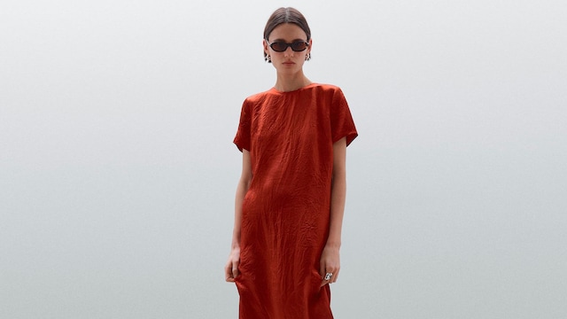 Mujer de pelo corto con vestido de manga corta naranja satinado de Massimo Dutti
