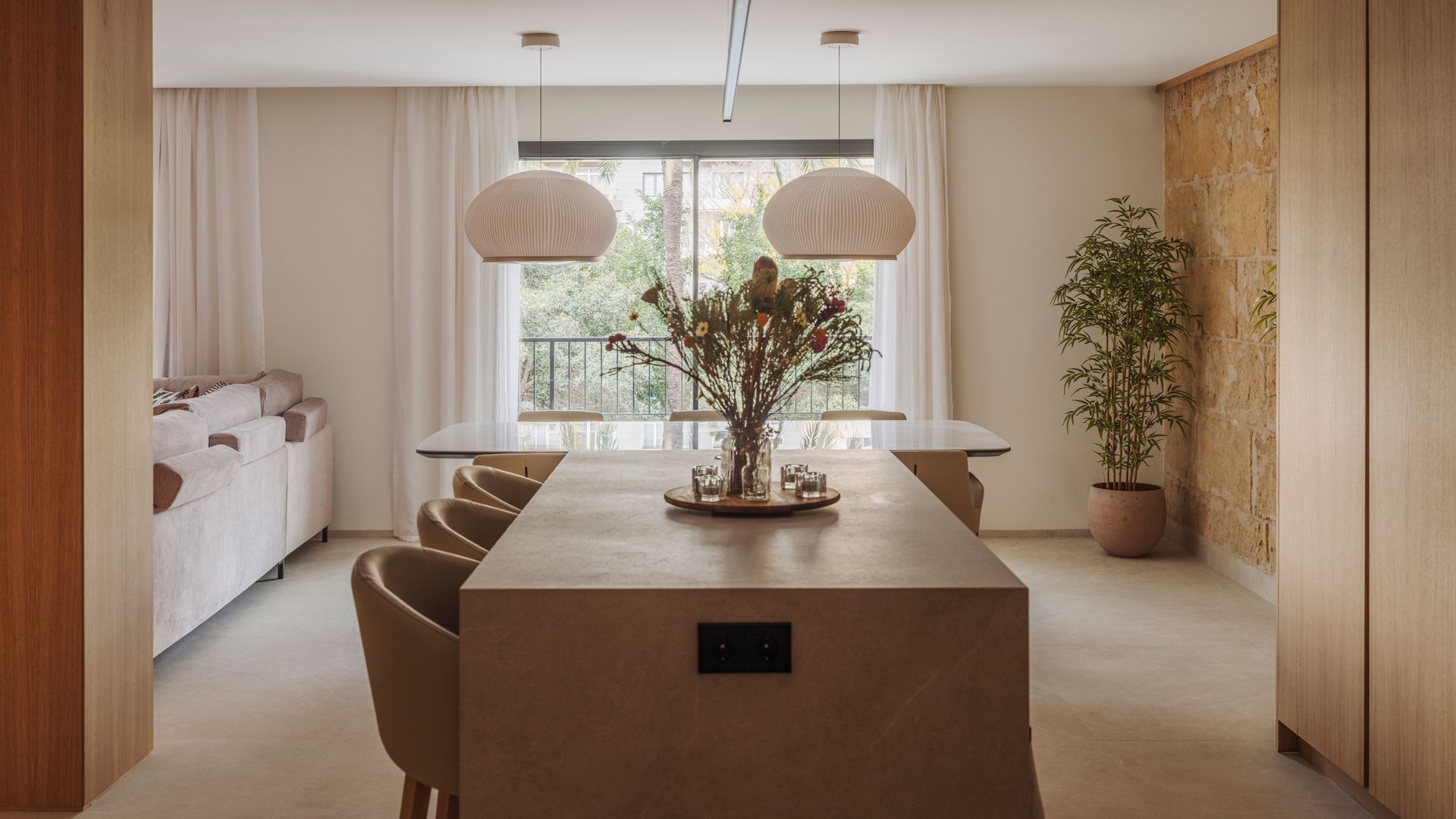 Salón, cocina y comedor, pared de ladrillo, lámparas de techo de papel, cortinas, ventanal con salida a la terraza