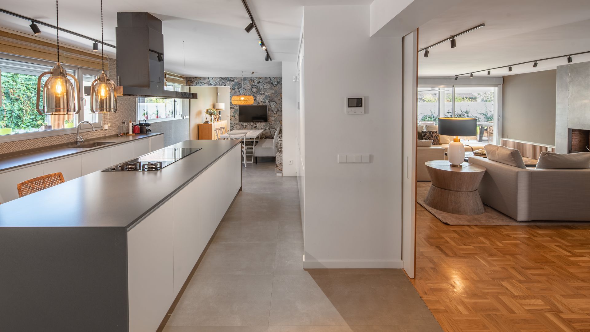Cocina con isla y office, salón, puerta corredera, suelo de madera