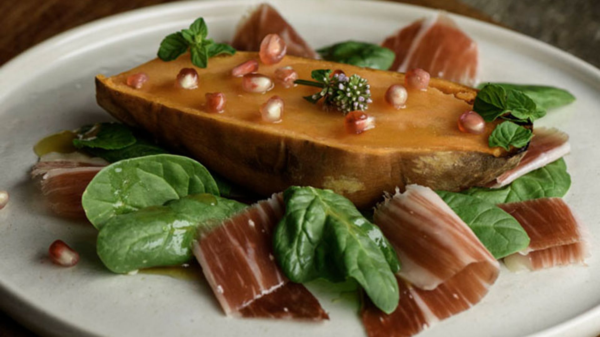 Boniato asado con jamón ibérico y vinagreta de miel y granada