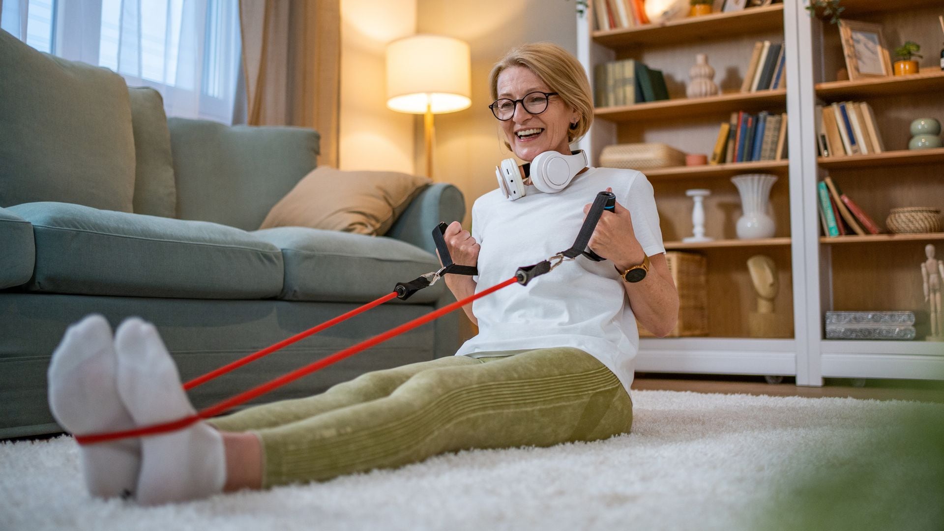 Mujer madura haciendo deporte con bandas elásticas en casa