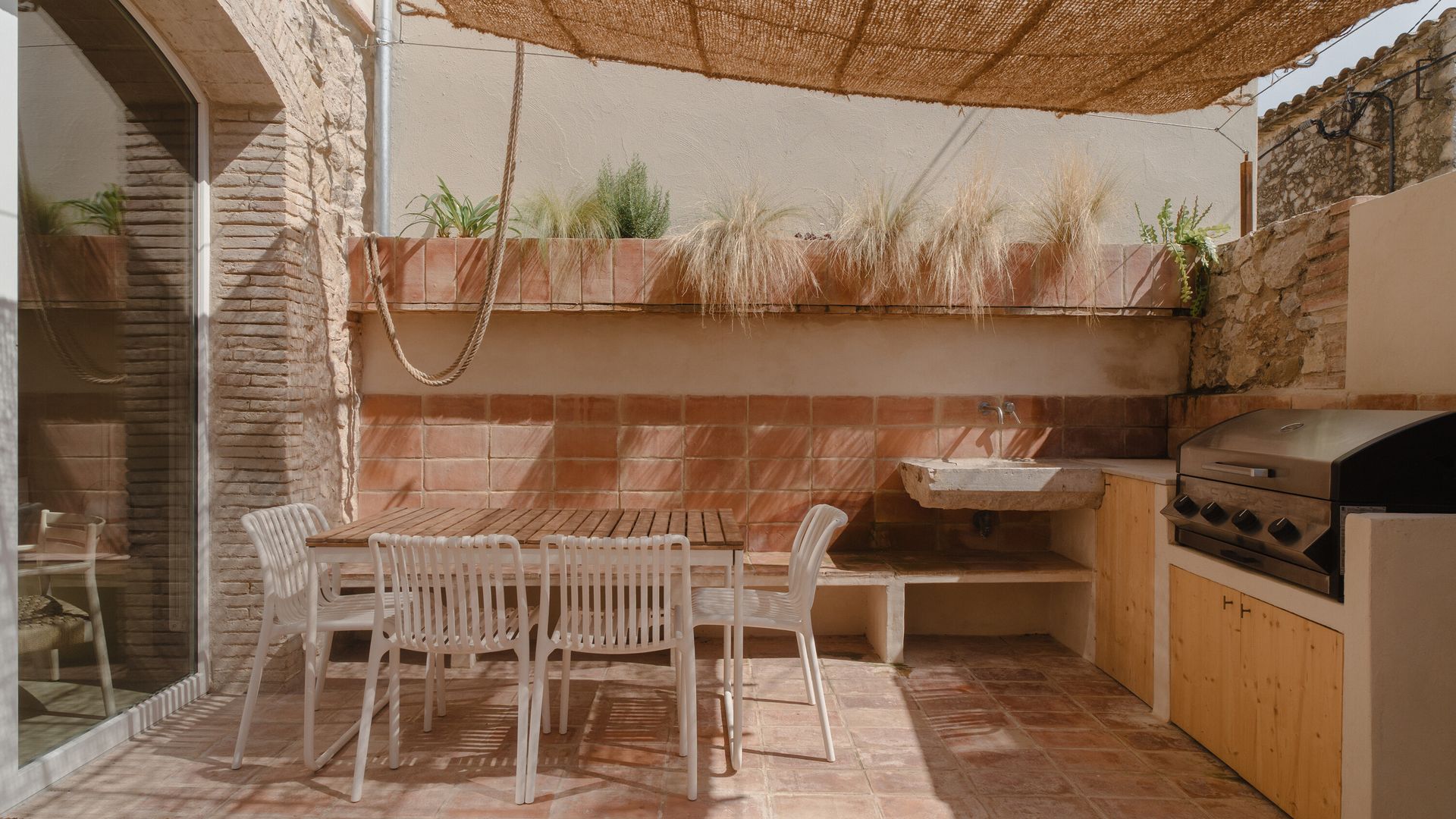 Patio con cocina exterior con banco, mesa de comedor exterior, pérgola de paja