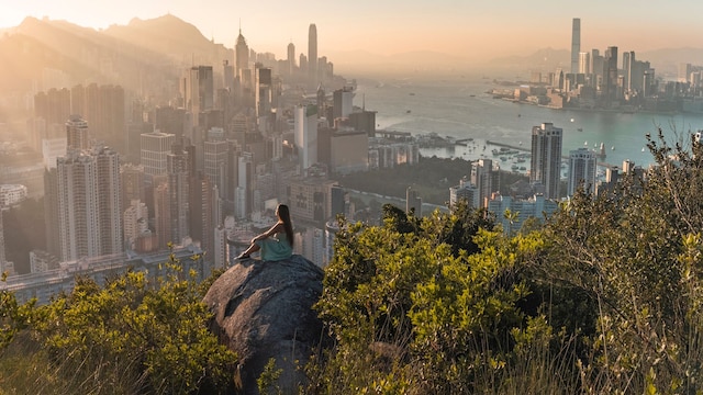 Mujer disfrutando del atardecer sobre la isla de Hong Kong, en el archipiélago chino del mismo nombre, el más deseado por los viajeros