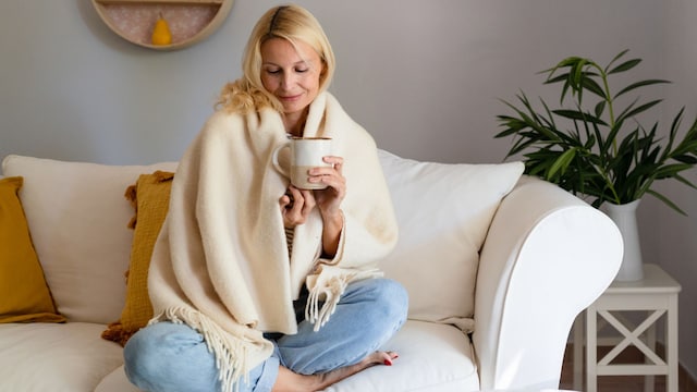 Mujer madura en la menopausia tomando taza de té