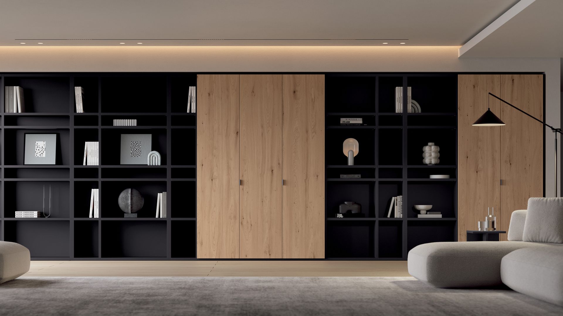 Salón con librería de pared a pared, con parte abierta de color negro y armarios incluidos de madera, techo con iluminación perimetral, chaise longue y lámpara de pie