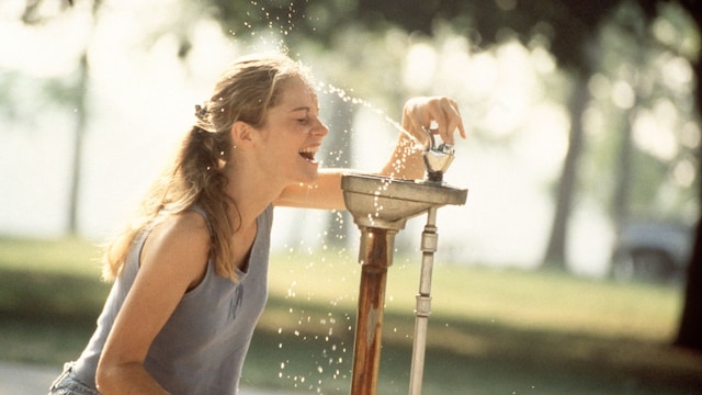 mujer refrescándose del calor en una fuente