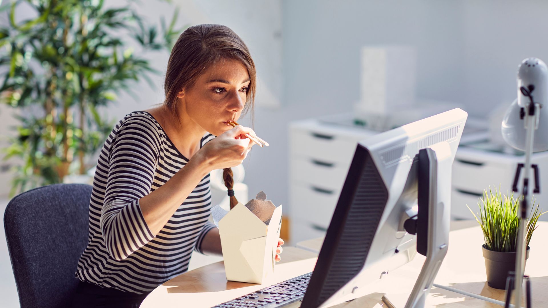 Mujer comiendo en la oficina 
