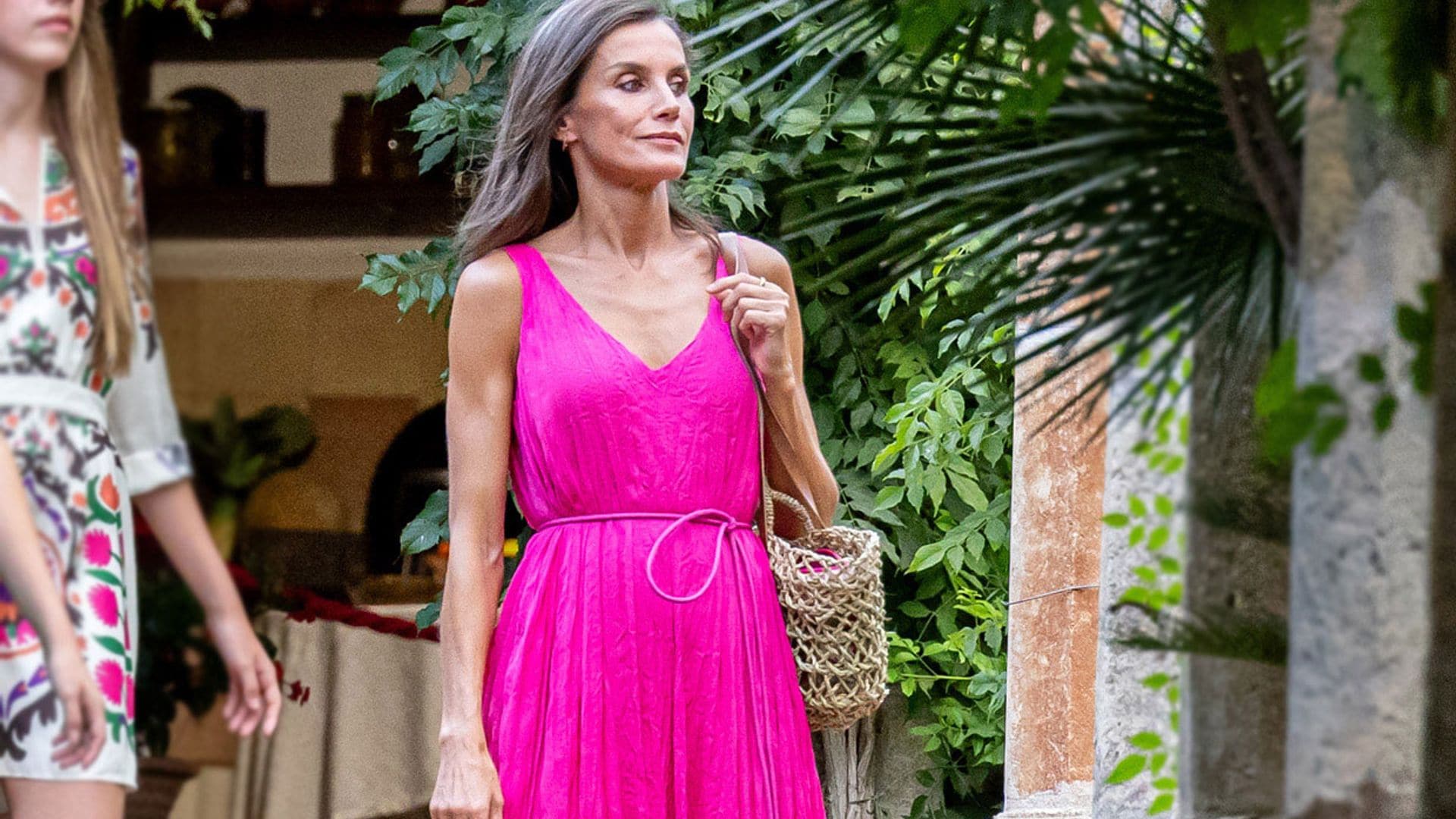 La reina Letizia posa en familia con un vestido fucsia de acabado arrugado y complementos rústicos