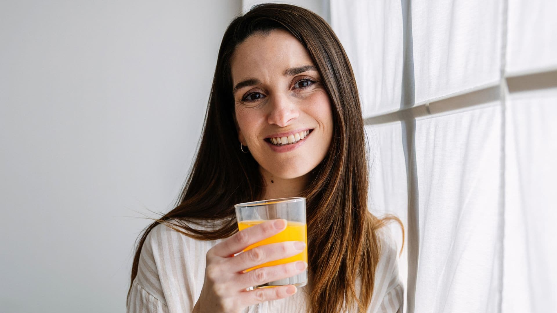 Una mujer tomando su suplemento de vitamina C