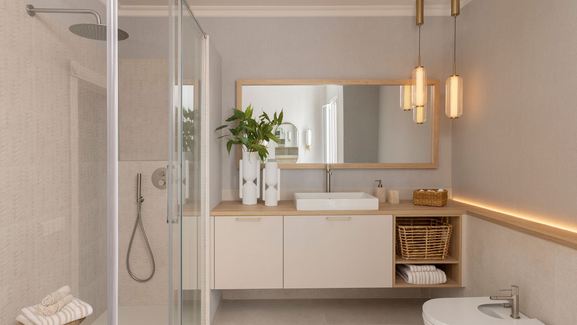 Baño con ducha y bidé, mueble bajolavabo blanco, espejo con el marco de madera, iluminación perimetral, lámparas de techo