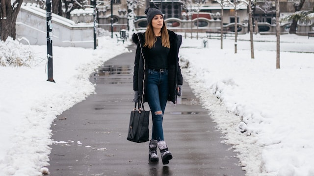 Mujer caminando por la ciudad con nieve