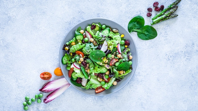 Ensalada de hojas verdes con tomates cherry, rábanos, garbanzos y pasas
