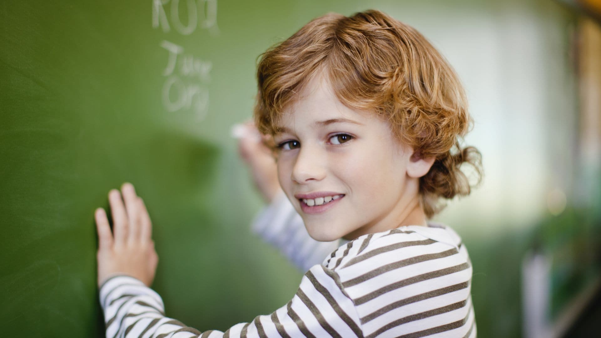 Niño escribe en la pizarra