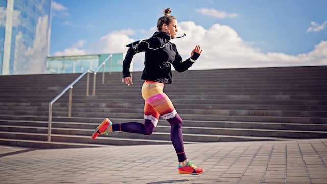Mujer corriendo en la calle con leggins y zapatillas de colores
