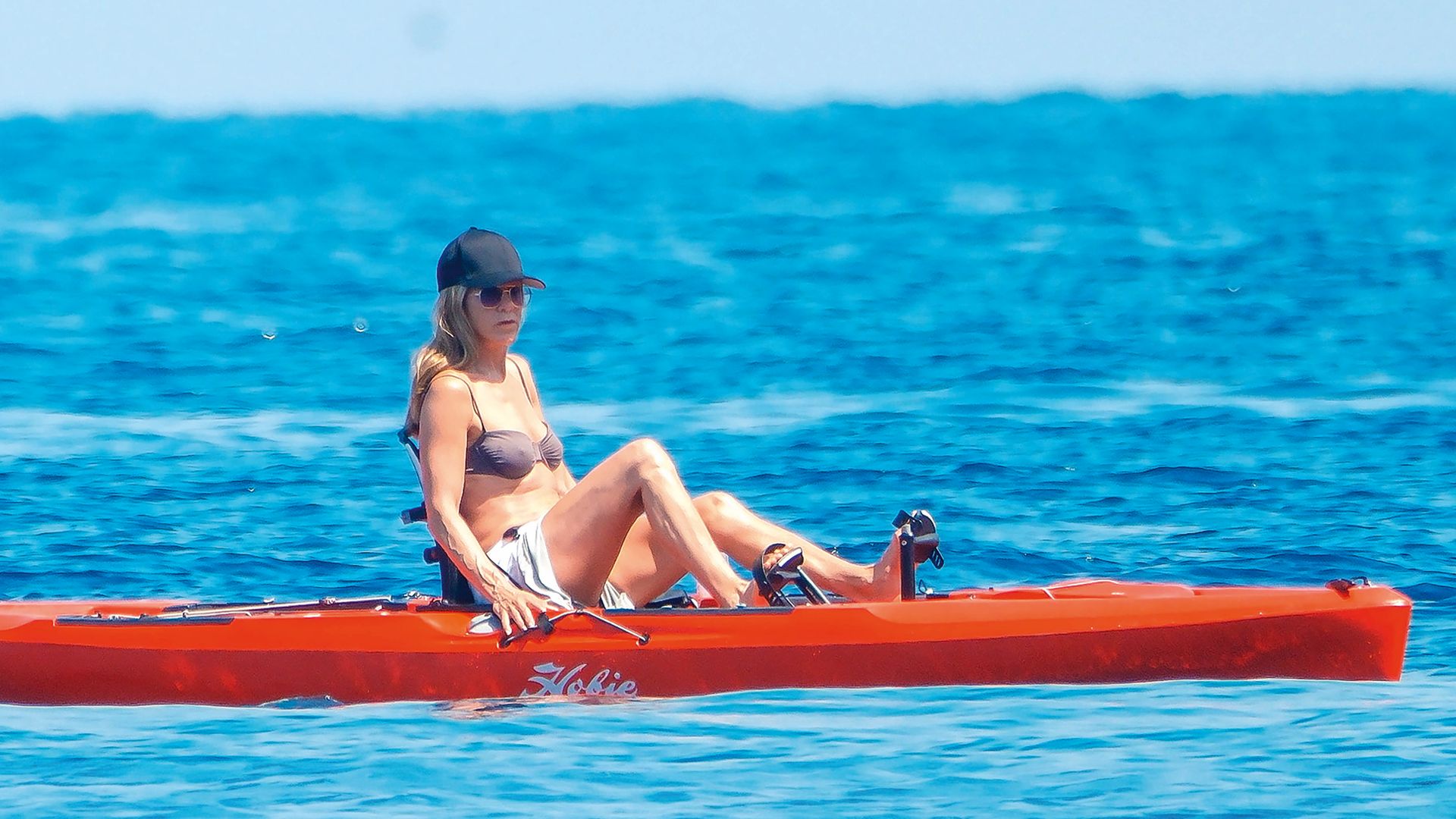 Arriba, Jennifer Aniston (57 años) demuestra su forma física practicando kayak
