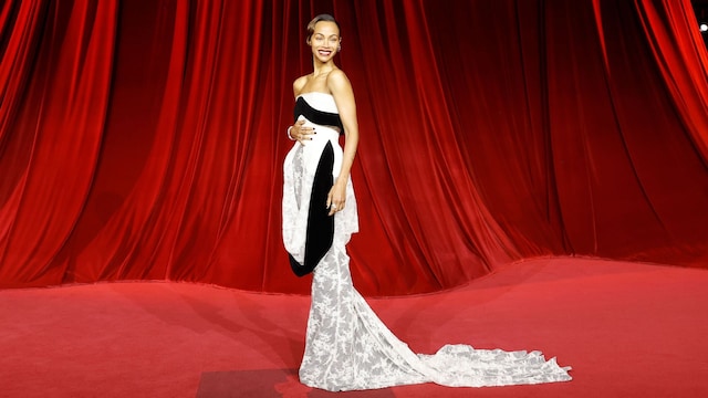 Plano entero de Zoe Saldaña en la Academy Museum Gala con vestido blanco con cola