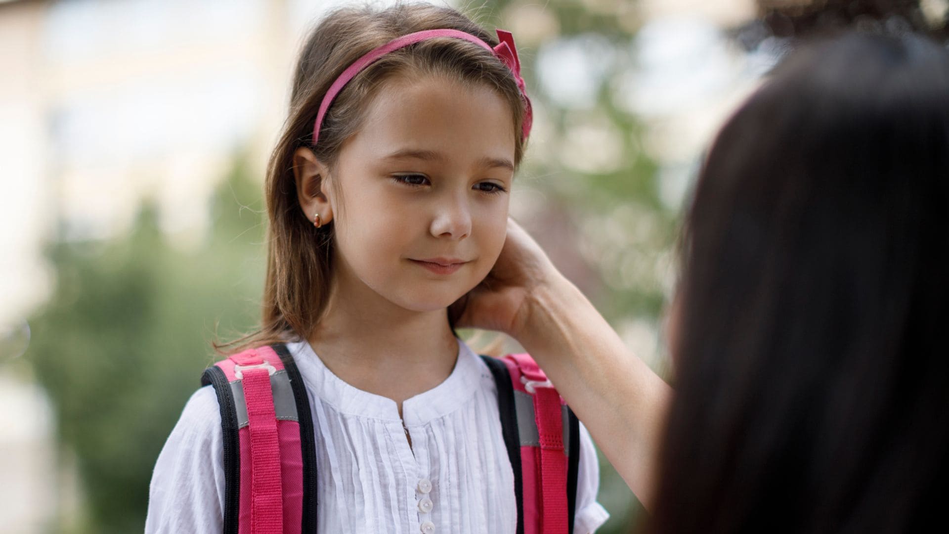 Madre apoya a su hija antes de entrar en el colegio
