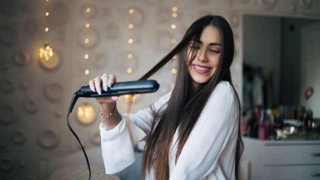 Un chica usando una plancha de pelo