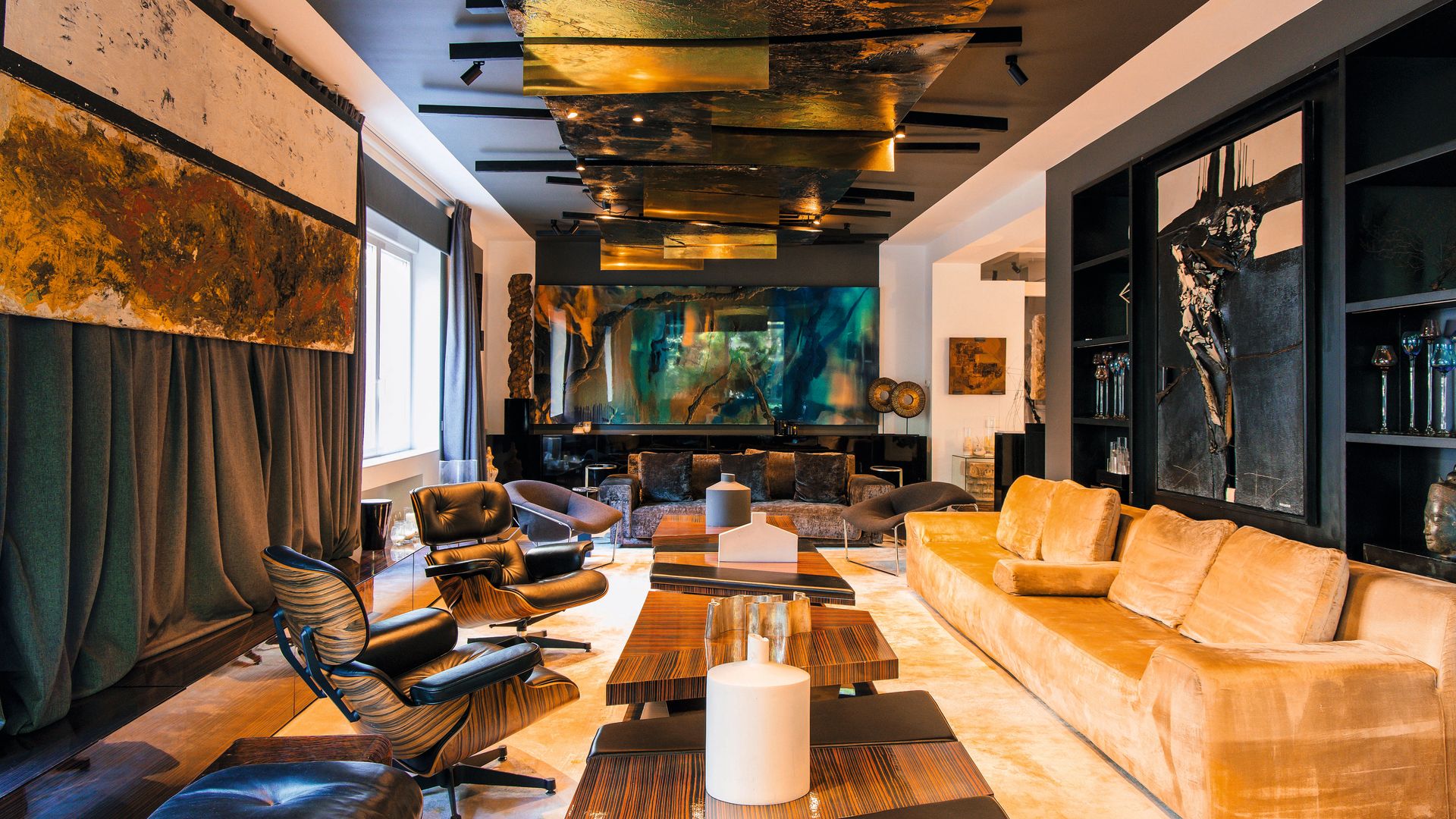 Una vista del salón principal de la vivienda. Todo el interiorismo ha sido concebido por el arquitecto junto a su estudio, A-cero. Las mesas de centro, realizadas en madera de ébano, y el sofá, tapizado en seda color champán, forman parte de sus propios diseños. En la pared cuelgan dos obras horizontales del artista Sicilia. Debajo, la sala de estar