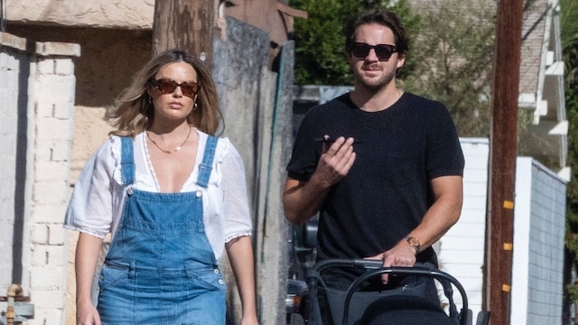 Plano medio de Margot Robbie y Tom Ackerley paseando con su bebé