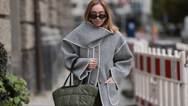 Sonia Lyson con capa gris y bolso acolchado en Berlín