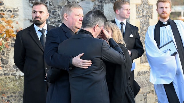Plano medio de Simon Cowell siendo consolado por los padres de Liam Payne en su funeral
