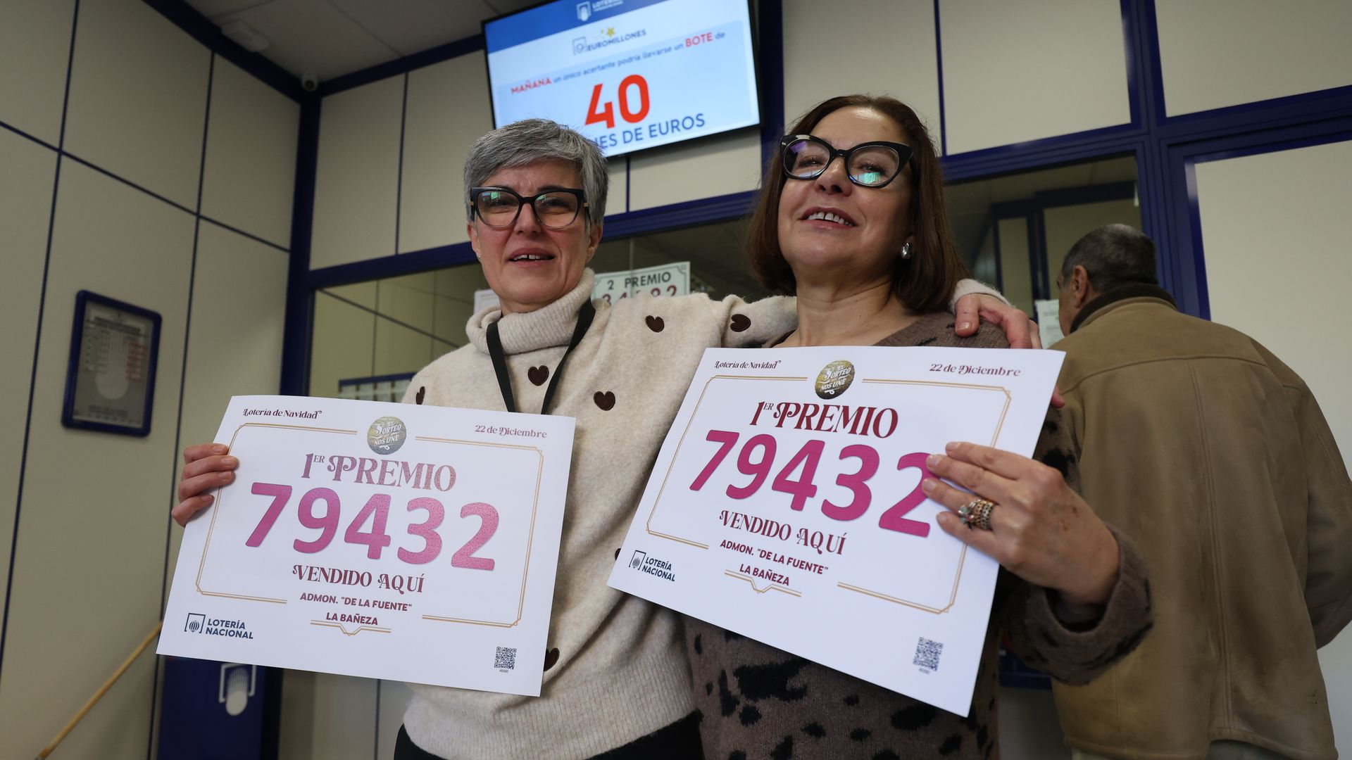 Euforia contenida en la administración de la plaza Obispo Alcolea, en La Bañeza (León), tras confirmar que desde este punto se vendió parte del 79.432, el número premiado con el Gordo de la Lotería de Navidad 2025