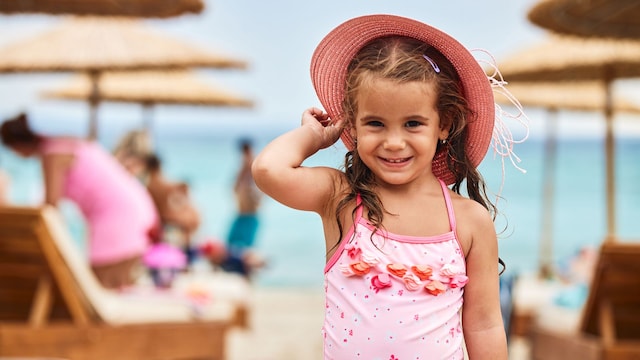 Niña con sombreor en la playa
