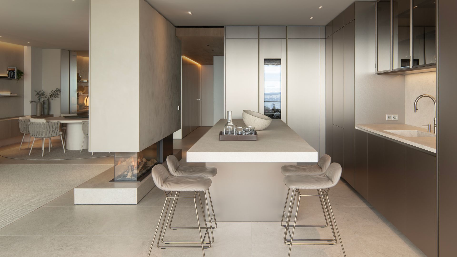 Cocina abierta al comedor con isla de cocina con zona para comer, chimenea en la pared que separa el comedor de la cocina, muebles hasta el techo