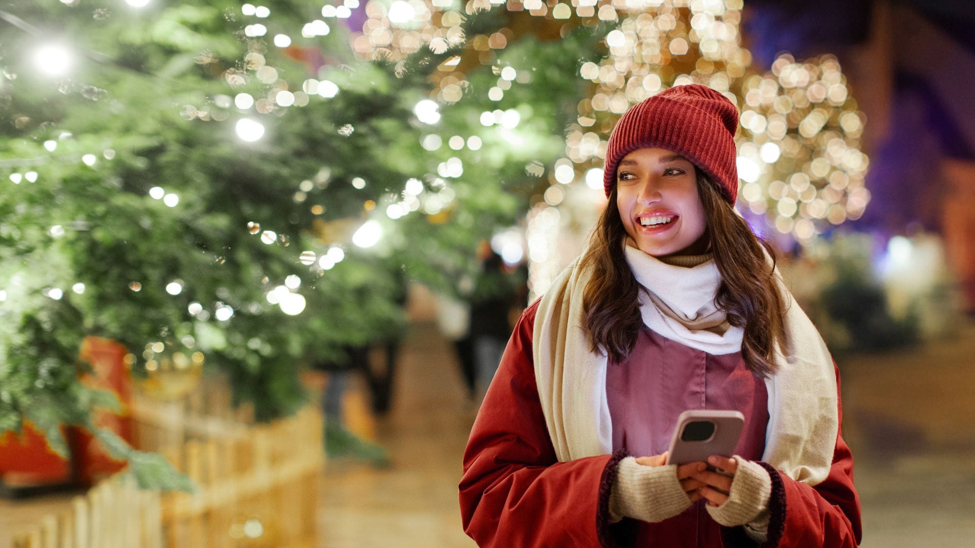 mujer sonriente con el móvil en la mano, en Navidad