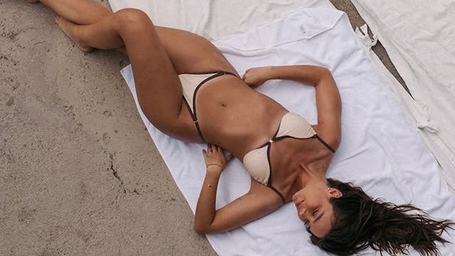 Modelo con bikini de MISSUS Swimsuits & Apparel tumbada en una toalla