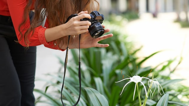 Mujer fotografiando una flor exótica