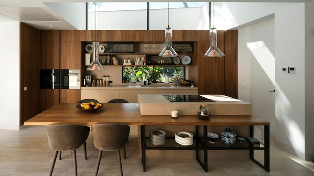 Cocina de madera con isla central con mesa de office, lámparas de techo, sillas tapizadas
